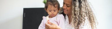 woman giving lunch to young child with Down