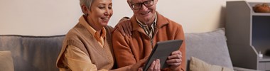 A man and a woman looking at a tablet together,